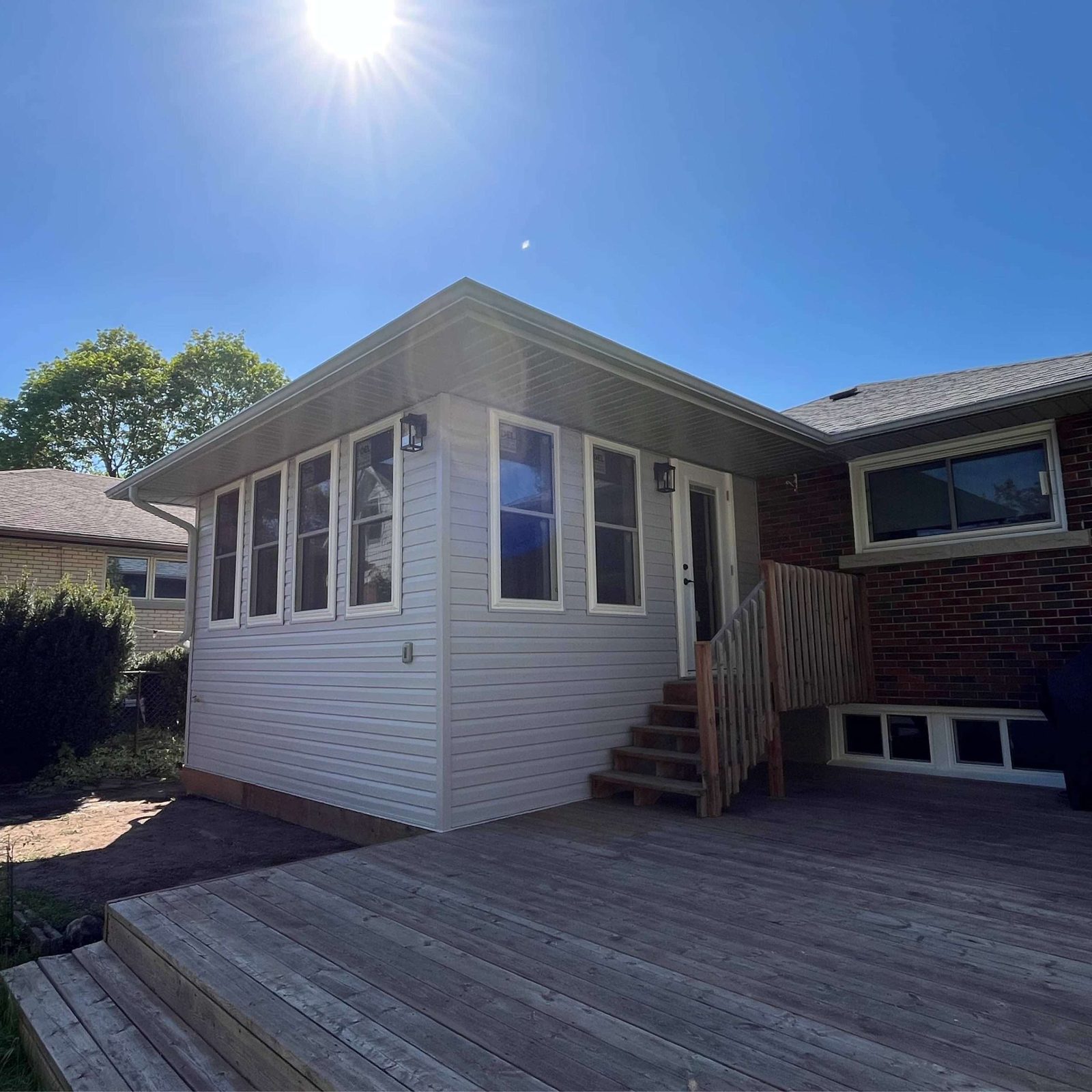Finished modern home addition with a deck and dark trim